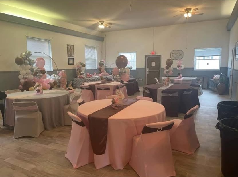 Full banquet room transformation with dressed round tables and soft floral centerpieces