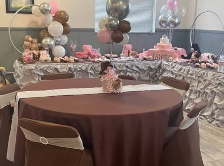 Long celebration table styled with layered linens, cake and considered detailing